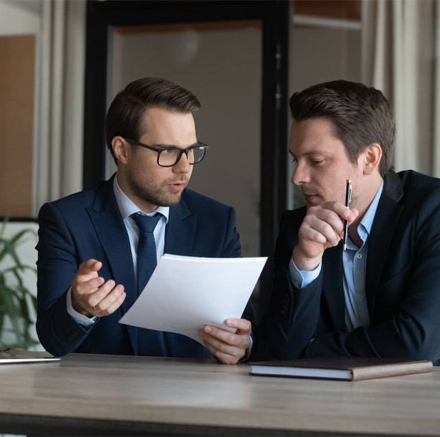 Image Showing two man in a business meeting looking at a document together